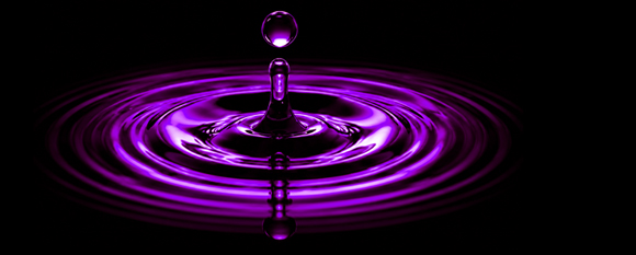 Purple water droplet creating ripples